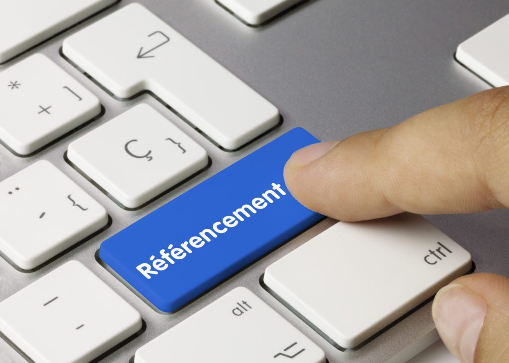 SEO : définition et types de référencement Doigt appuyant sur une touche bleue « Référencement » d’un clavier, pour illustrer SEO, SEA, SMO et SEM
